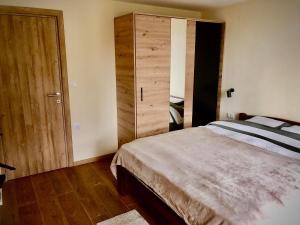 Schlafzimmer mit einem Bett und einem Holzschrank in der Unterkunft Imanje POGLED in Aranđelovac