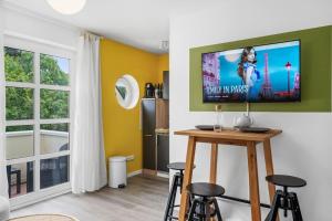 uma sala de estar com uma televisão de ecrã plano na parede em Grünes Wohnen in Düren em Düren - Eifel