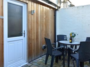 a patio with a table and chairs and a door at Meadow View Cottage in Stanhope