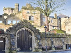 an old stone building with a large gate and a street light at Meadow View Cottage in Stanhope