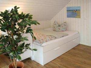 Bett in einem Zimmer mit einer Pflanze in der Unterkunft Apartments im Schwedenstil in Papenburg