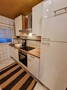 a kitchen with white cabinets and a white refrigerator at Idylle pur in der Nähe der Autostadt in Oebisfelde