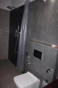 a bathroom with a shower and a toilet in it at Coorg Happy Estate Stay in Madikeri +15 photos
