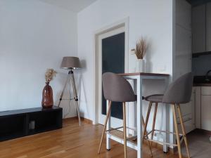 a kitchen with two chairs and a table in a room at Balcony Apartment, 5 min Walk to First District in Vienna