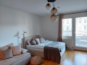 a living room with a bed and a couch at Balcony Apartment, 5 min Walk to First District in Vienna