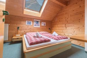 a bedroom with a bed in a wooden cabin at Därfli Appartements in Sankt Gallenkirch