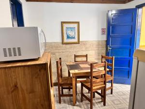 cocina y comedor con mesa y sillas en Pousada La Croix, en Florianópolis