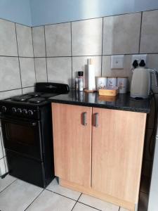 a kitchen with a stove and a counter top at Cosy apartment with secure parking in Johannesburg