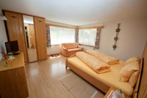 ein Wohnzimmer mit einem Sofa und einem Stuhl in der Unterkunft Hotel Gemse in Weisstannen