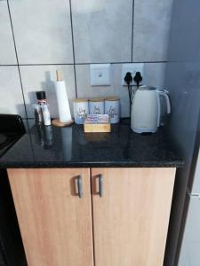 a kitchen counter top with a coffee maker and appliances at Cosy apartment with secure parking in Johannesburg