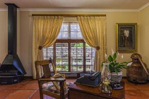 Peter's Guesthouse في بريتوريا: غرفة معيشة مع طاولة ونافذة كبيرة