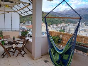 a hammock on a balcony with a table and chairs at Apartmani Ljumović Budva in Budva