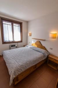 a bedroom with a large bed and a window at RESIDENCE-RESORT BORGO AL SOLE in Sappada