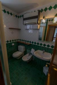 uma casa de banho com 2 lavatórios, um WC e um espelho. em RESIDENCE-RESORT BORGO AL SOLE em Sappada