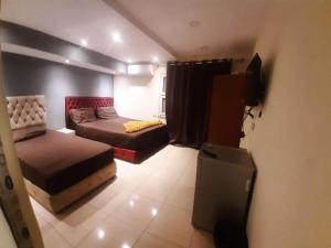 a bedroom with two beds and a television in it at Blue Eyes Hotel in Cairo