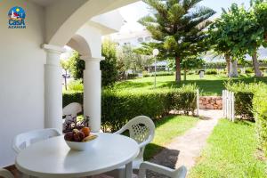 a white table with a bowl of fruit on a patio at Residencial Al Andalus Casa Azahar in Alcossebre