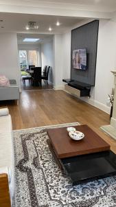 a living room with a table and a tv at Large 4 Bedrooms House in Coventry for Contractors in Whitley