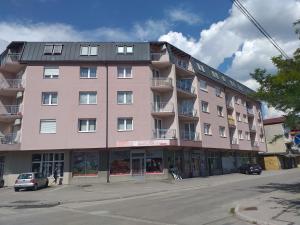 a large pink building on the corner of a street at Apartment Ilidza-SK in Sarajevo