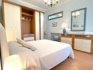 una camera con un grande letto bianco e una scrivania di Villa DilettaMaria a Forte dei Marmi
