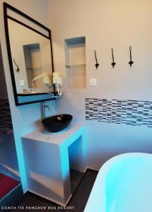 a bathroom with a black sink and a mirror at Pangkor Bus Resort by BESLA in Pangkor