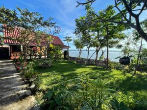 a house with a garden and the ocean in the background at Anouxa Riverview Guesthouse in Champasak