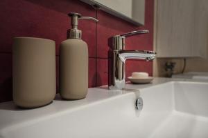 a bathroom sink with a soap bottle next to a faucet at Modern Apartment on the Mt.Baldo & Garda Lake in Brentonico