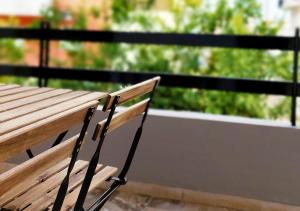 un banc en bois posé au sommet d'un balcon dans l'établissement Habitat Nafplio bnb-The Dreamers Apartment, à Nauplie