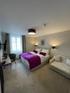 um quarto com uma cama grande e um sofá em Hotel Radetzky em Sankt Gilgen