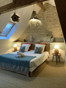 um quarto com uma cama grande numa parede de pedra em Aquarelle em Sainte-Maure-de-Touraine