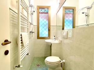 bagno con servizi igienici, lavandino e vetrate istoriate di Villa DilettaMaria a Forte dei Marmi