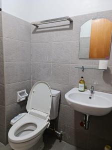 a bathroom with a toilet and a sink at Mesatierra Garden Residences in Davao City