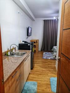 a small kitchen with a sink and a refrigerator at Mesatierra Garden Residences in Davao City