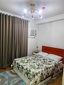 een slaapkamer met een bed en een gordijn bij Mesatierra Garden Residences in Davao City