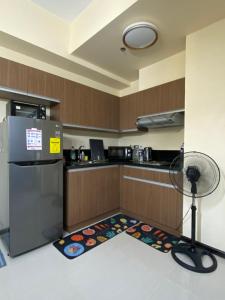 a kitchen with a refrigerator and a fan on the floor at Le 10 The Radiance Manila Bay in Manila