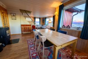 a dining room with a wooden table and chairs at Cozy house on Sommarøy in Sommarøy