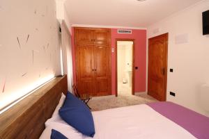 een slaapkamer met een bed en een rode muur bij 204 I Posada del Mar I Encantador hostel en la playa de Gandia in Los Mártires