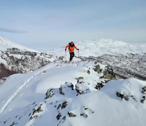 a person on skis on a snow covered mountain at Turismo y Cabañas Dragon de La Patagonia in Cochrane