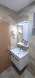 a bathroom with a white sink and a mirror at KovacInalux Apartmani in Pale