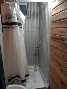 y baño con ducha y cortina de ducha. en Cabaña 2 en Mar del Plata