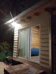 una gran ventana en el lateral de una casa por la noche en Cabaña 2 en Mar del Plata