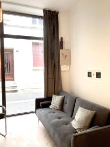 a living room with a couch and a large window at Serene Sixteen - Valence Centre Ville in Valence