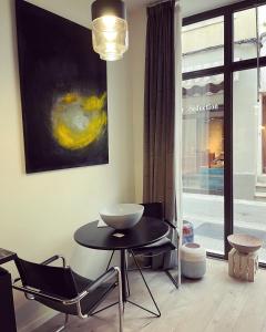 un comedor con mesa, sillas y una pintura en Serene Sixteen - Valence Centre Ville, en Valence