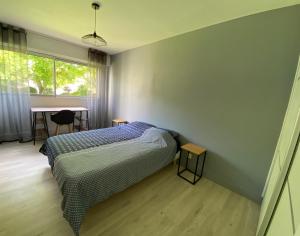 1 dormitorio con cama, mesa y ventana en Magnifique appartement à deux pas du centre ville!, en Quimper