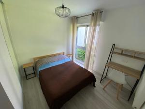 Habitación pequeña con cama y ventana en Magnifique appartement à deux pas du centre ville!, en Quimper