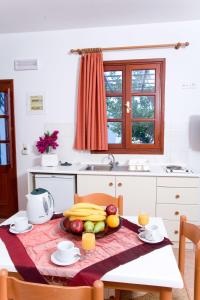 a kitchen with a table with fruits and vegetables on it at Anastasia Studios Lindos in Lindos