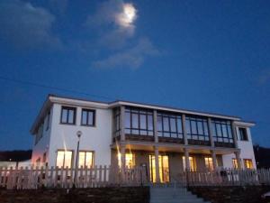 Una casa blanca con la luna en el cielo en APARTAMENTOS LAS OLAS BY PANTIN, en Valdoviño