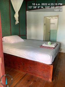 Una cama en una habitación con un espejo. en Pa Kha Guesthouse, en Muang Không