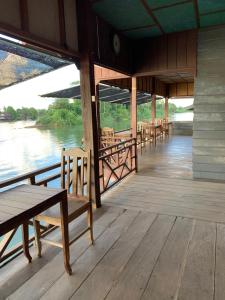 a row of tables and chairs on a dock at Pa Kha Guesthouse in Muang Không