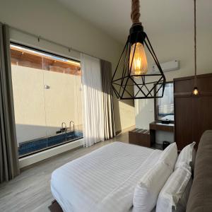 a bedroom with a bed and a large window at اكواخ سنتارا الريفيه in Taif