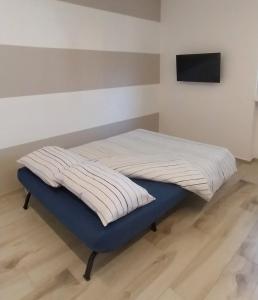 uma cama não feita com uma placa de pé azul num quarto em Casa DelFalco em Domodossola